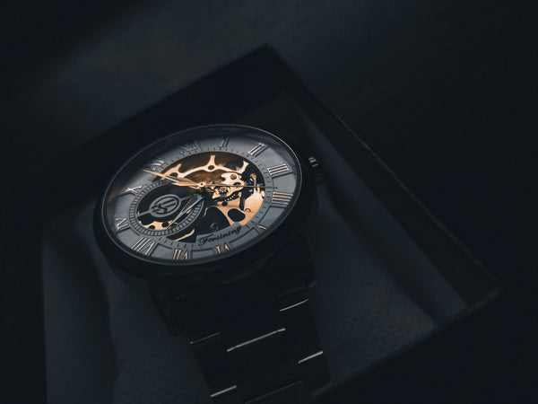 Skeletonised luxury sports watch on dark background